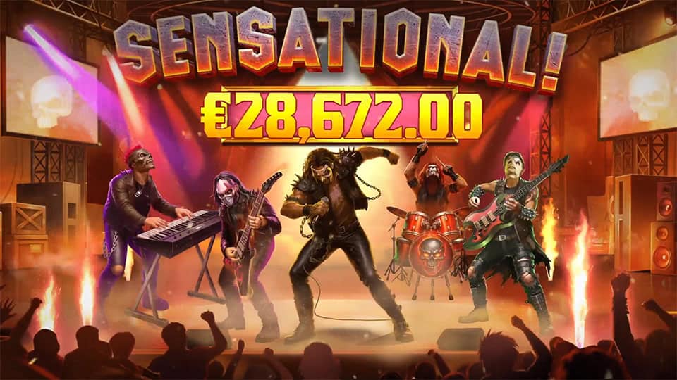 Full rock band on stage with &ldquo;SENSATIONAL!&rdquo; win banner and crowd cheering.
